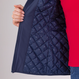 Navy quilted jacket with red sleeve on a grey background