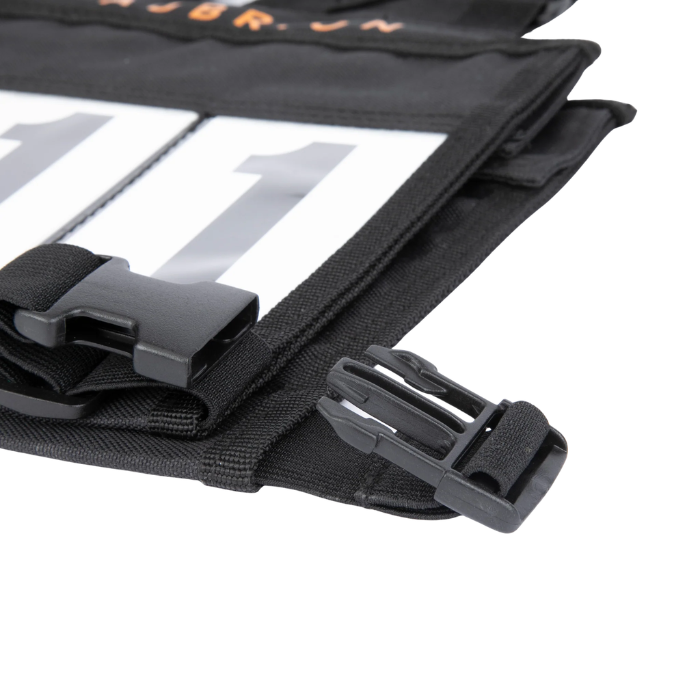 Close-up of a black bag with straps and a visible brand logo on a white background