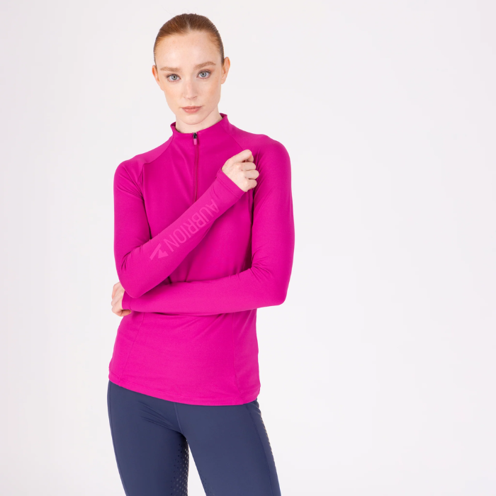 Woman wearing a bright pink long-sleeve athletic top on a white background
